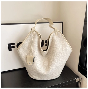 Detail view of large sherpa fleece tote bag with PU leather trim on minimalist background