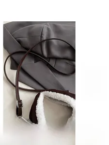 Détail d'un sac en peluche marron avec doublure en molleton blanc et bandoulière en cuir