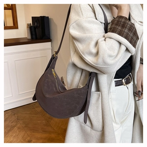 Detail of vintage dark brown hobo bag with gold zipper and textured synthetic leather