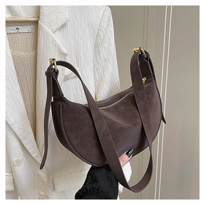 Close-up of vintage brown leather dumpling bag with gold hardware and zipper detail