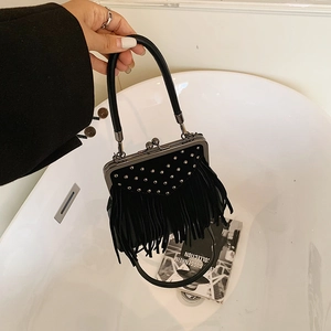 Detail of black fringe handbag featuring silver studs and vintage metal clasp closure