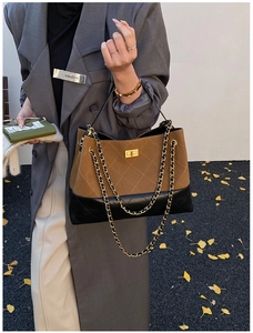 Detail of vintage quilted chain bag featuring brown suede and black leather patchwork