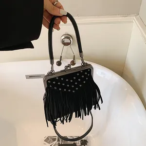 Close-up of black fringe handbag featuring silver rivets and metal clasp detail