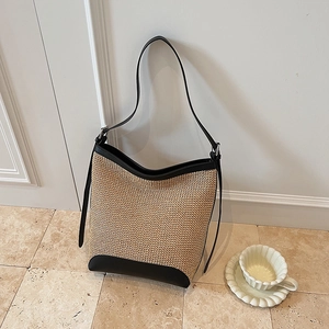 Borsa a secchiello in paglia minimalista con patchwork in pelle nera e tracolla lunga