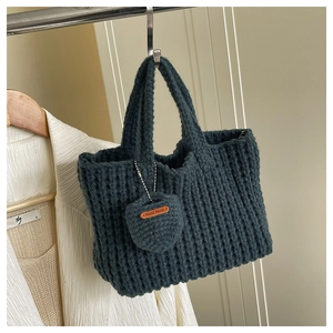 Detailed close-up of dark green handmade woven handbag showing thick cotton knit texture
