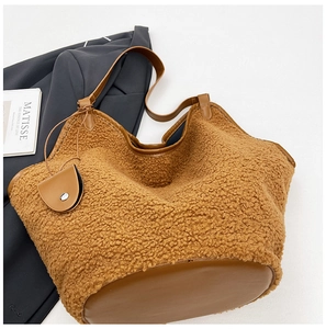 Detail of faux shearling tote bag featuring leather straps and matching round coin purse