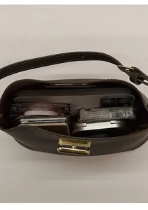Top view of compact crossbody bag showing golden H buckle and spacious inner storage