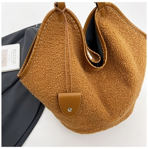 Brown teddy fleece tote bag with leather trim and decorative metal cylinder tag