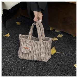 Detailed knit texture of handmade khaki crochet tote bag with Hand Made leather tag