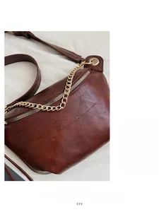 Détail de sac banane vintage marron avec chaîne dorée et texture plissée souple