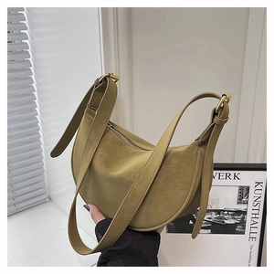 Detail of mustard yellow crescent shoulder bag featuring adjustable strap and gold hardware