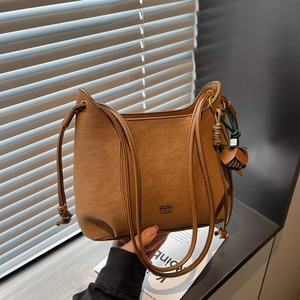 Chic brown textured leather underarm bag with thin straps and floral bag charm