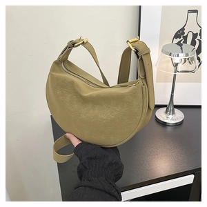 Detail of vintage olive green hobo bag featuring retro leather texture and golden buckle