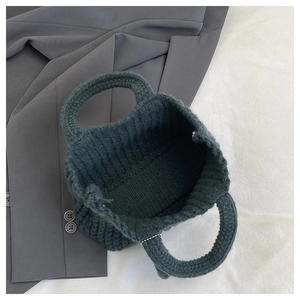 Top view of hand-knitted green cotton shoulder bag with textured crochet interior detail