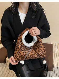 Détail du sac en peluche léopard avec poignées en fausse fourrure blanche et nœud à pompons