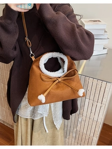 Détail du sac en daim marron avec bordure en fausse fourrure blanche et nœud à pompon