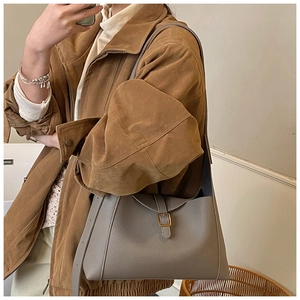 Détail du sac à bandoulière en cuir grainé taupe avec une boucle dorée élégante