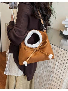 Détail du sac bandoulière en daim marron avec grand nœud et bordure en fausse fourrure