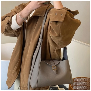 Détail du sac croissant en cuir gris à motif litchi avec boucle dorée élégante