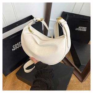 Detail of white hobo bag with pebbled leather texture and golden zipper hardware