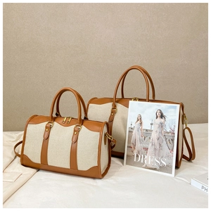Detail of beige canvas and brown leather boston travel bags in two different sizes
