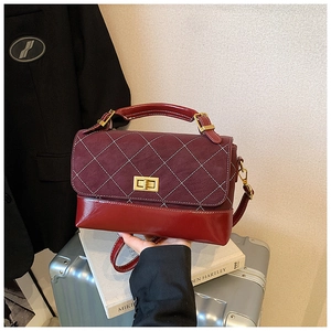 Detail of retro burgundy quilted patchwork handbag with gold rectangular twist lock