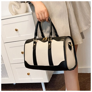 Detail of Boston-style canvas handbag with black leather trim and metal zipper hardware