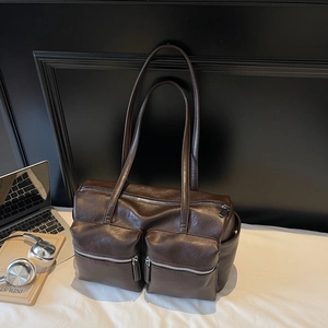 Deep brown oversized shoulder bag in glossy faux leather with dual front zipper pockets