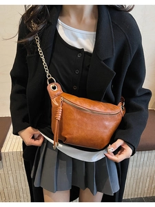Détail du sac en similicuir marron souple avec chaîne dorée et tirette de zip tressée