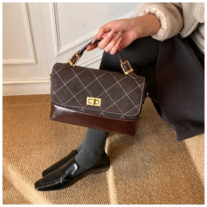 Detail of vintage rhombic stitching and brown leather splicing with golden twist lock