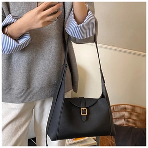 Détail du sac bandoulière en cuir grainé noir avec boucle carrée dorée élégante