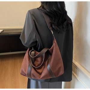 Vue détaillée du grand sac cabas en daim marron avec anses en cuir sur le dos du mannequin