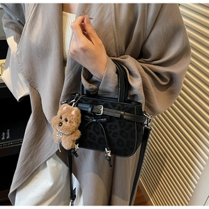 Détail du sac léopard avec breloque ours en peluche et pendentif étoile métallique