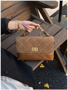 Detailed view of vintage brown bag with quilted suede and golden buckle in autumn setting