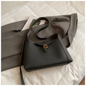 Détail du sac cabas en cuir noir texturé avec boucle carrée en métal doré élégante