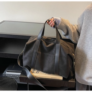 Gros plan d'un sac cabas en daim noir avec poignées en cuir et fermeture éclair