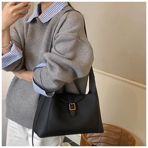 Détails du sac demi-lune noir grainé avec boucle carrée dorée et texture cuir élégante