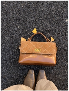 Macro detail of retro quilted texture and gold twist lock on brown leather handbag
