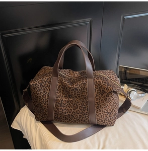 Détail du sac cabas léopard avec anses en cuir marron et fermetures éclair dorées