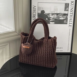 Handmade chunky knit underarm bag in dark brown with matching mini charm and leather tag