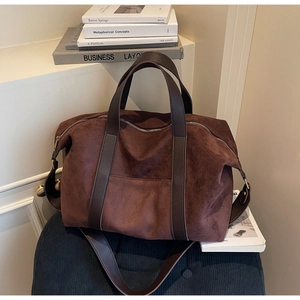 Détail du sac cabas en daim marron avec anses en cuir foncé et ferrures en bronze rétro