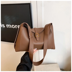 Détail du sac à main en cuir marron grainé avec boucle dorée et bandoulière large