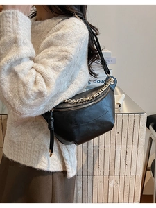 Détail du sac croissant en cuir noir avec chaîne dorée et long tirette à pompon