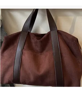 Détail du sac fourre-tout en daim marron foncé avec anses en similicuir durable