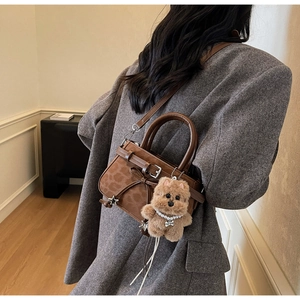 Détail du sac léopard avec breloque étoile et pendentif chien en peluche doux