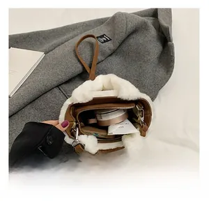 Detail showing internal storage capacity with white faux fur trim on brown suede bag