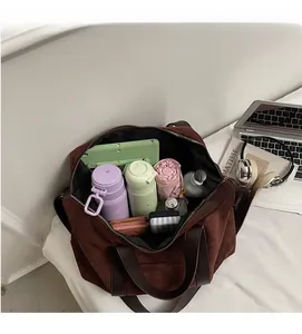 Intérieur spacieux d'un sac cabas en daim marron contenant tablette et accessoires