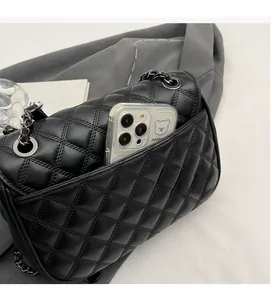 Close-up of black quilted chain bag back pocket showing practical storage for a smartphone