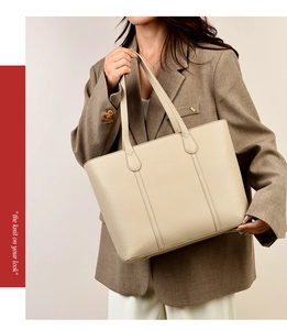 Sac cabas chic crème avec texture litchi porté par un mannequin en style pro