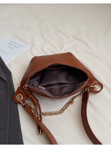 Détail du sac bandoulière en cuir souple marron montrant la doublure et la poche zippée